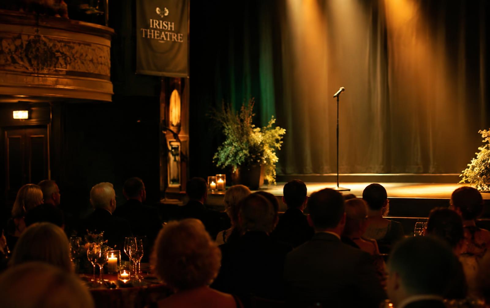 A theatre stage set for a charity gala, with a microphone under warm lights